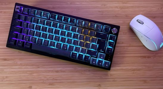 Corsair K65 Plus Wireless with gaming mouse on a wooden desk