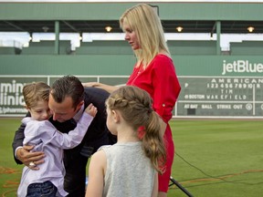 Le lanceur des Red Sox de Boston, Tim Wakefield, embrasse son fils, Trevor, 7 ans, tandis que sa femme, Stacy, à droite, et sa fille, Brianna, 6 ans, regardent après que Wakefield a annoncé sa retraite en 2012.