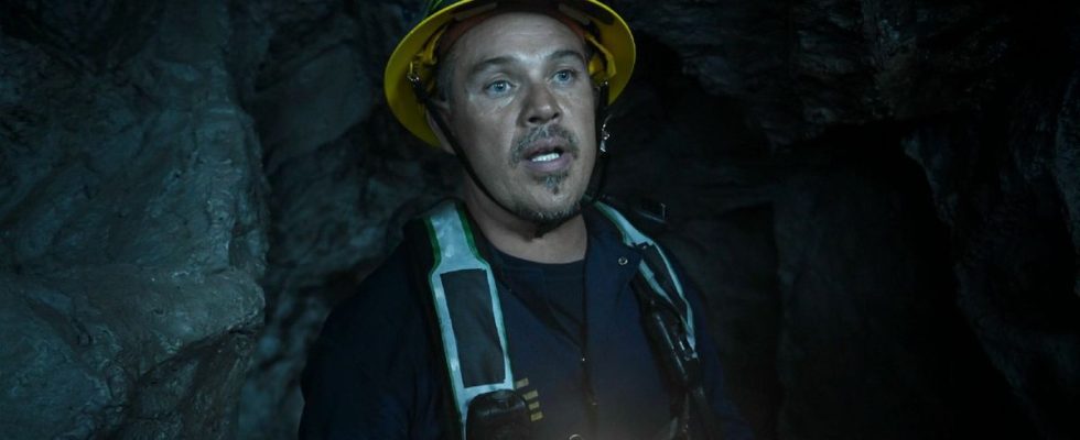 Pictured: Kevin Alejandro as Manny Perez in a cave wearing a hard hat and light..