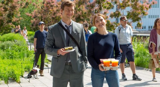 Glen Powell and Zoey Deutch standing next to each other and holding drinks in a press image for Set It Up.