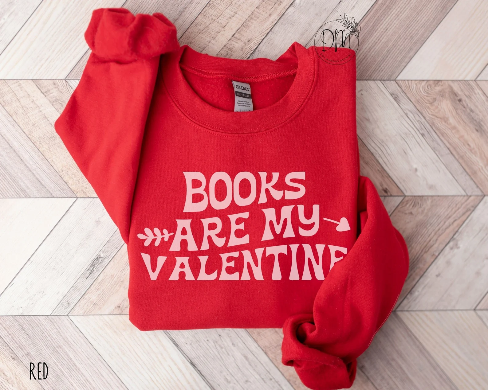 Image d'un sweat-shirt rouge avec les mots "les livres sont ma Saint-Valentin" en rose. 