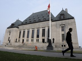 Un homme passe devant la Cour suprême du Canada à Ottawa.
