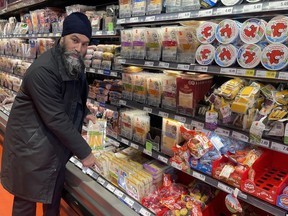 Le chef du NPD, Jagmeet Singh, montre un paquet de fromage d'une valeur de 20 $ lors d'une visite dans une épicerie Loblaws à Ottawa le mercredi 21 février 2024.