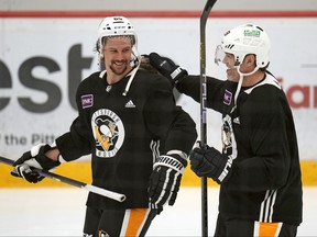 Erik Karlsson des Penguins de Pittsburgh, à gauche, partage un rire avec l'ancien joueur des Penguins Jaromir Jagr qui s'est joint à l'équipe pour une séance d'entraînement lors d'un entraînement de hockey de la LNH, le samedi 17 février 2024, à Cranberry, en Pennsylvanie.