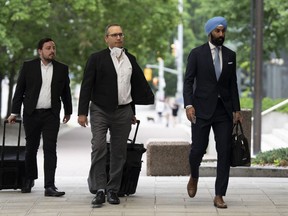 .  L'ancien député libéral Raj Grewal, à droite, marche avec ses avocats alors qu'ils se rendent au tribunal, le lundi 18 juillet 2022, à Ottawa.