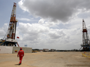 Un ouvrier pétrolier marche à côté d'appareils de forage dans un puits de pétrole exploité par la compagnie pétrolière nationale vénézuélienne PDVSA.