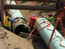 Des travailleurs posent des tuyaux pendant la construction de l'agrandissement du pipeline Trans Mountain sur des terres agricoles, à Abbotsford, en Colombie-Britannique, le mercredi 3 mai 2023.