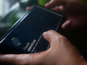 Une personne tient un smartphone réglé sur l’écran d’ouverture de l’application ArriveCan dans une illustration photographique réalisée à Toronto le 29 juin 2022.