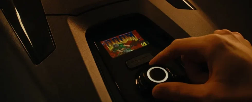 A hand controlling Doom on a robotic lawnmower screen.