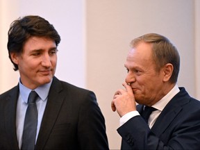 Le Premier ministre Justin Trudeau, à gauche, et le Premier ministre polonais Donald Tusk réagissent lors d'une conférence de presse conjointe à Varsovie le 26 février 2024. (Photo de SERGEI GAPON/AFP via Getty Images)