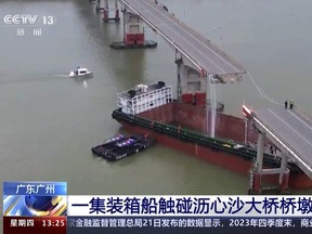 Dans cette image tirée d'une vidéo diffusée par CCTV chinoise, des gens inspectent le pont Lixinsha brisé après avoir été heurté par un porte-conteneurs dans le district de Nansha à Guangzhou, dans la province chinoise du Guangdong (sud), le jeudi 22 février 2024.