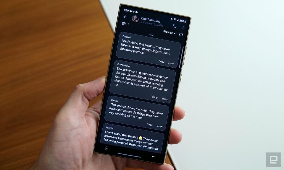 Photo du Galaxy S24 Ultra dans la main de quelqu’un.  Son écran affiche les alternatives suggérées par l'IA à un message de discussion.