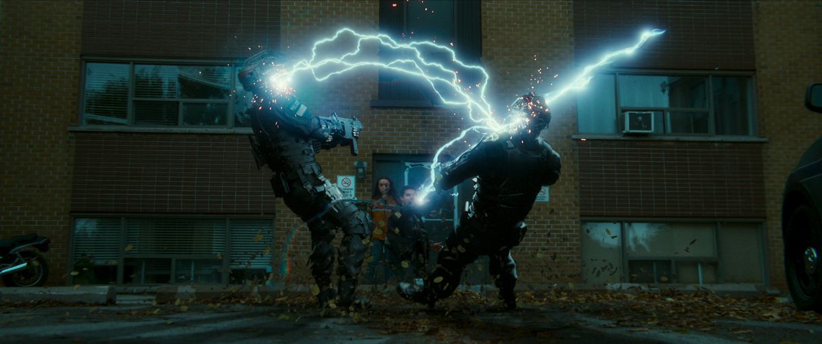 Un homme tire des éclairs avec ses mains, frappant deux agents en uniforme, dans le code 8, partie II.