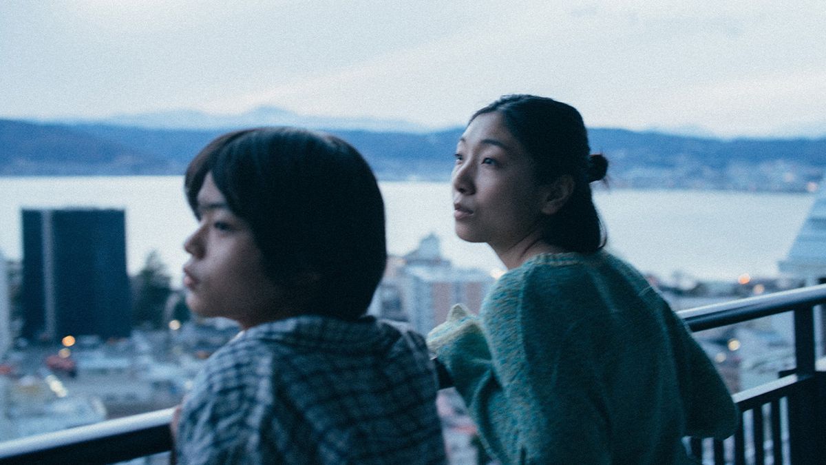 Sakura Andō et Sōya Kurokawa s'appuient sur une balustrade au-dessus d'un paysage urbain dans Monster
