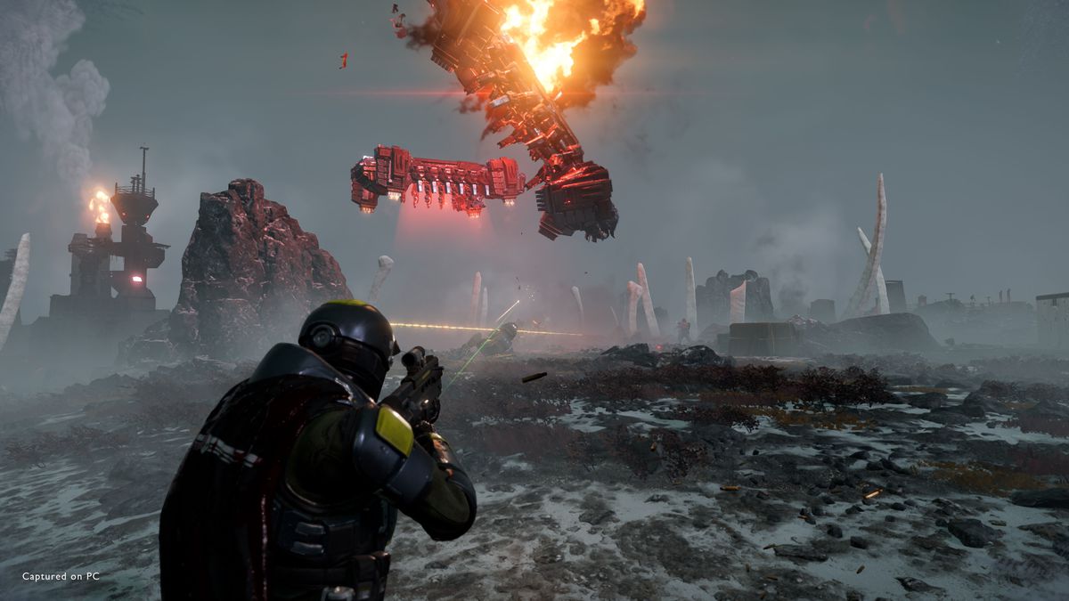 Un Helldiver tirant sur un vaisseau automate qui explose en flammes.