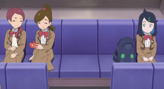 Liko from Pokemon Horizons the Series sitting on a bus next to two classmates, all in school uniform