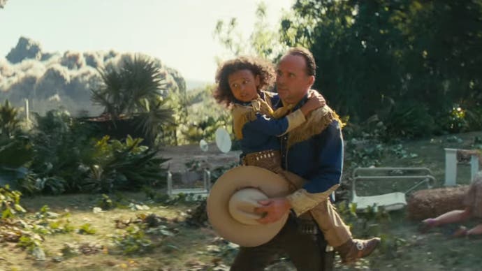 Walton Goggins dans le rôle de Cooper Howard dans la série télévisée Fallout d'Amazon tenant un enfant alors qu'il fuit une explosion