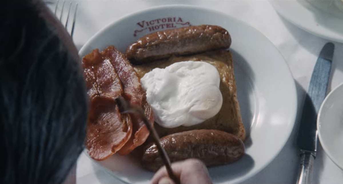 Gros plan d'une assiette de bacon, de saucisses, de morceaux rares gallois et d'œufs pochés de l'hôtel Victoria