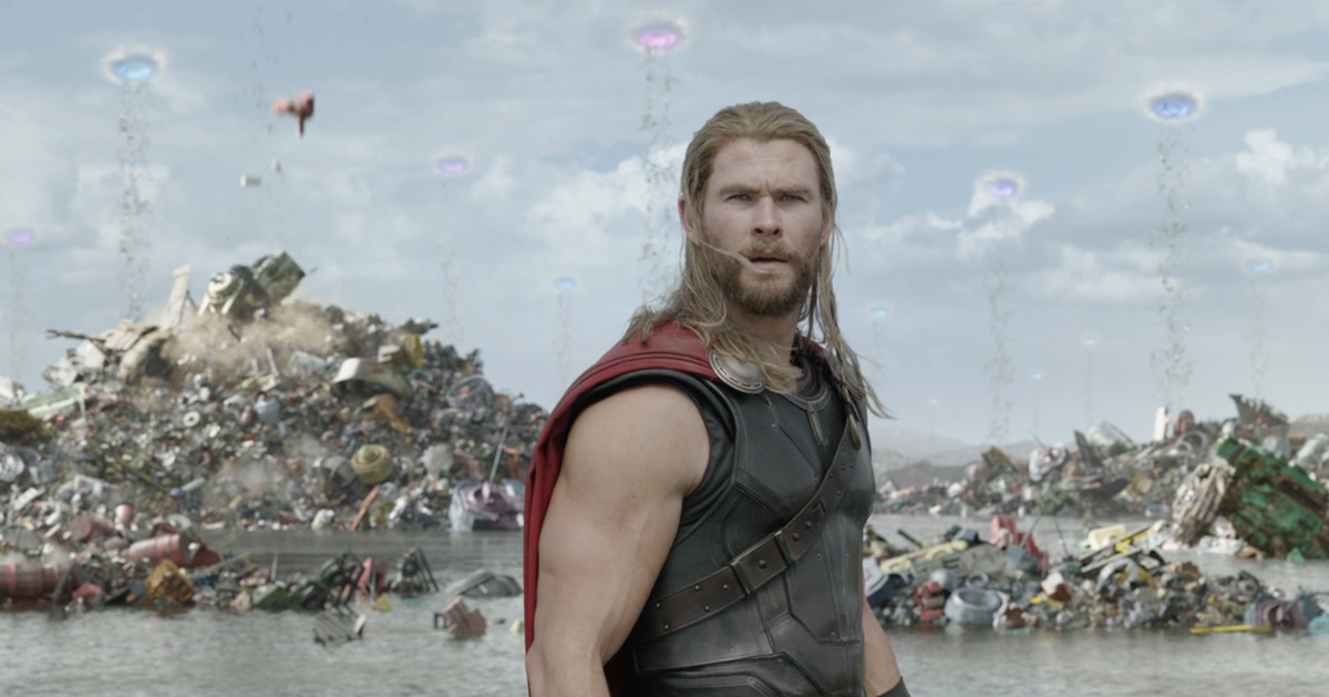 Thor regarde autour de lui, perplexe, devant ce qui ressemble à un tas d'ordures géant.  Dans le ciel derrière lui, on peut voir des portails d'où tombent des déchets jusqu'au sol. 