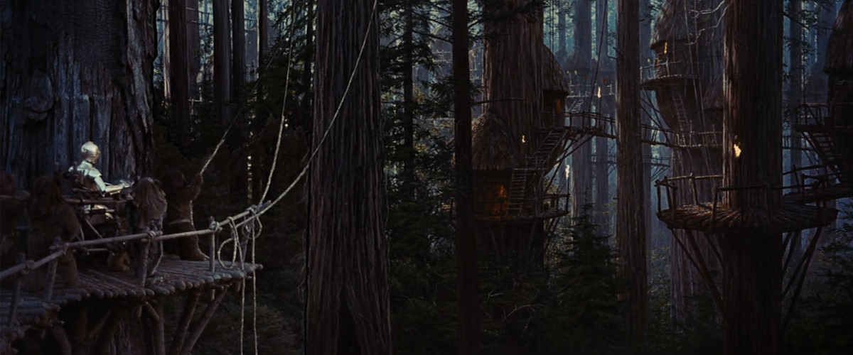 Les Ewoks portent C-3PO sur un trône sur une plate-forme en bois dans le village boisé des Ewok. 