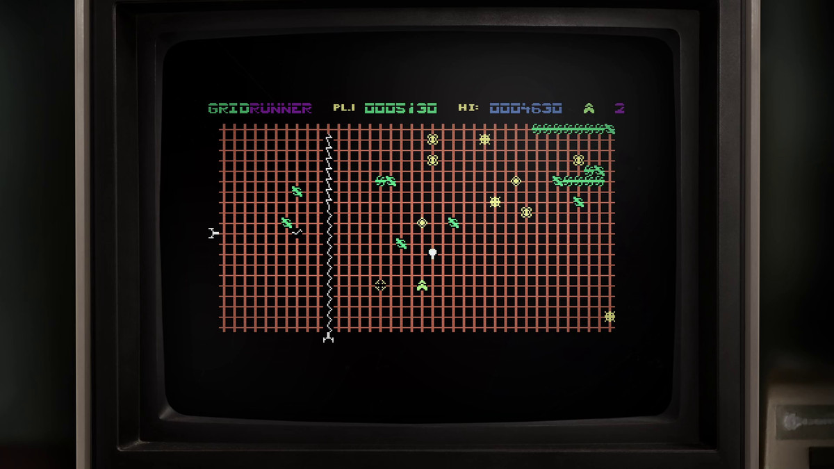 Une capture d'écran de Gridrunner, encadrée par un vieux moniteur de télévision, montrant ses graphiques simples en 8 bits