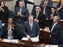 Le ministre des Finances et du Conseil du Trésor, Allan MacMaster, en bas au centre, est applaudi par les membres du parti lors du dépôt du budget provincial à l'Assemblée législative de la Nouvelle-Écosse, à Halifax.