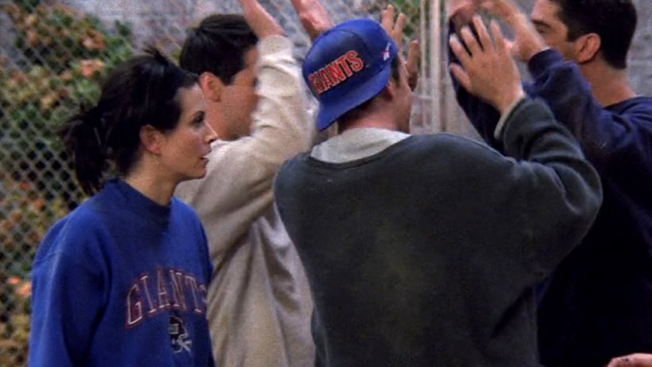 Monica et Chandler portant une chemise et un chapeau des Giants sur Friends.
