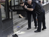 Un enquêteur de la police de Vancouver allume un couteau sur le trottoir à l'extérieur de l'Université Fairleigh Dickinson à Vancouver, en Colombie-Britannique, le 20 mars 2024, théâtre d'une agression grave survenue environ une heure plus tôt.