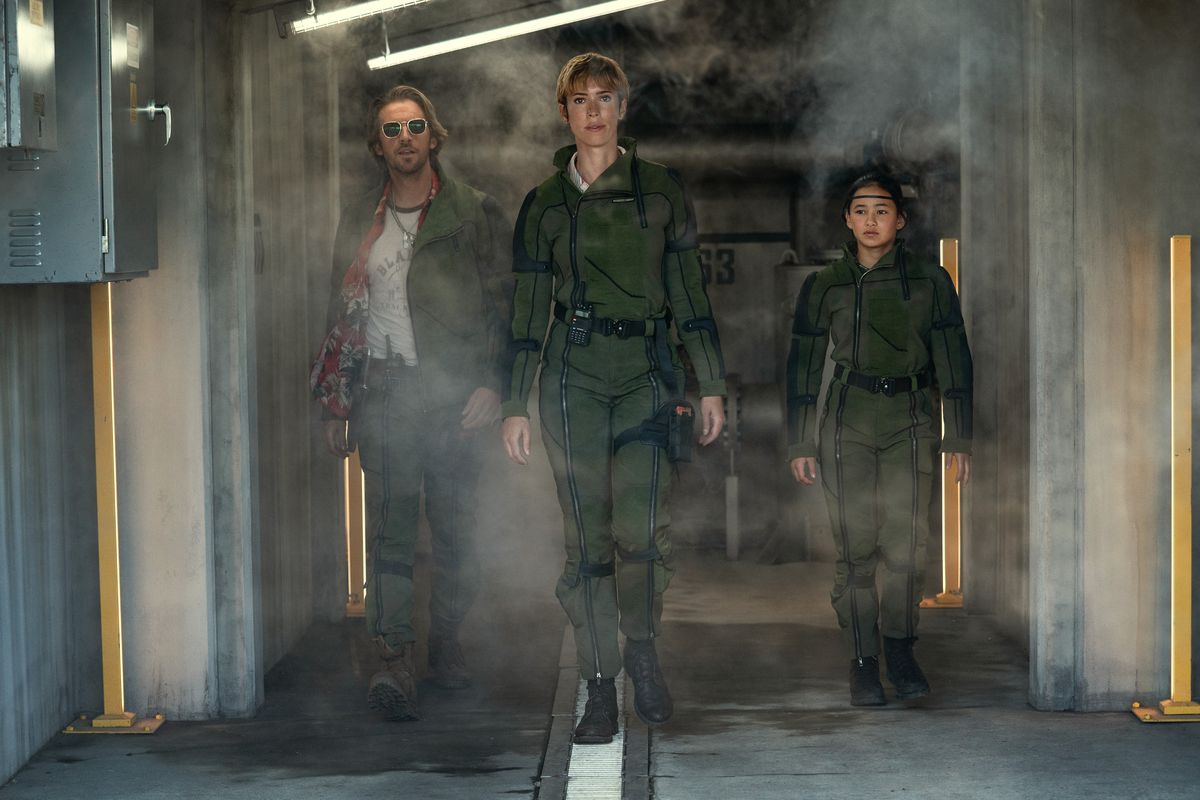 Dan Stevens, Rebecca Hall et Kaylee Hottle traversent un couloir enfumé, très cool, dans Godzilla x Kong : The New Empire