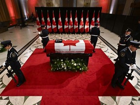 Des sentinelles entourent le cercueil de l'ancien premier ministre Brian Mulroney alors qu'il repose en état à l'édifice Sir John A. Macdonald, en face de la Colline du Parlement à Ottawa, le mardi 19 mars 2024.