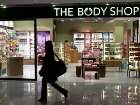 Une femme passe devant un magasin de cosmétiques Body Shop.