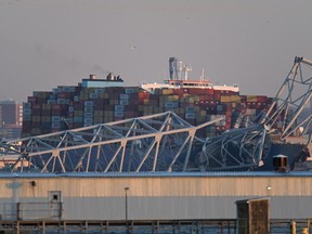La charpente en acier du pont Francis Scott Key se trouve au sommet d'un porte-conteneurs après qu'il a heurté le pont à Baltimore, Maryland, le 26 mars 2024.