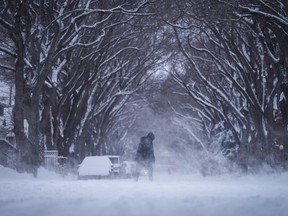 Une personne emmitouflée pour le froid marche dans la poudrerie à Regina, le dimanche 3 mars 2024.