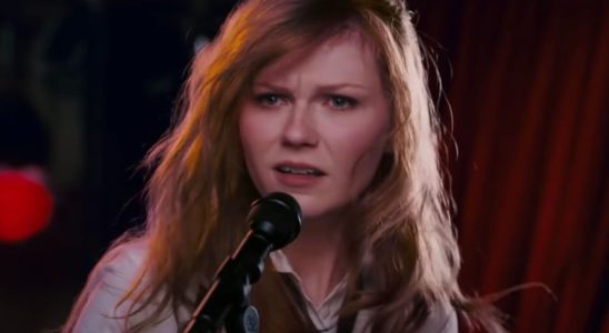 Kirsten Dunst stands perplexed in front of a microphone in Spider-Man 3.
