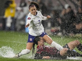 Alex Morgan, des États-Unis, ci-dessus, entre en collision avec Vanessa Gilles, du Canada, lors de la première moitié d'un match de demi-finale du tournoi de football féminin de la Gold Cup de la CONCACAF, le mercredi 6 mars 2024, à San Diego.