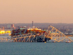 La charpente en acier du pont Francis Scott Key se trouve au sommet d'un porte-conteneurs après qu'il a heurté le pont à Baltimore, Maryland, le 26 mars 2024.