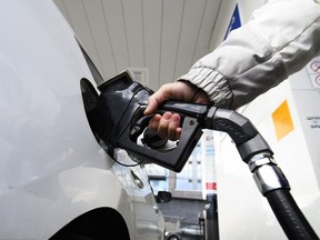Une femme fait le plein d'essence dans une station-service à Mississauga, en Ontario, le 13 février 2024.