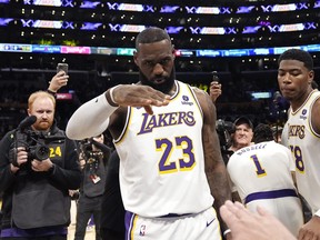L'attaquant des Los Angeles Lakers LeBron James salue l'annonceur public Lawrence Tanter avant un match de basket-ball NBA contre les Denver Nuggets le samedi 2 mars 2024 à Los Angeles.