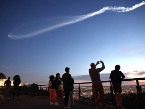 Les gens regardent une fusée SpaceX Falcon 9 transportant une charge utile de 22 satellites Internet Starlink dans l'espace à Los Angeles.