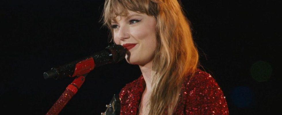 A screenshot of Taylor Swift smiling while singing All Too Well during the Eras Tour.