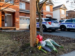 Fleurs et voitures de police devant la maison d'Ottawa où six personnes ont été tuées, le 7 mars 2024.
