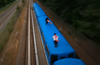 Capture d'écran d'une vidéo de deux hommes tenant des drapeaux canadiens au sommet d'un train TTC Scarborough RT.  On ne sait pas quand les images ont été prises.