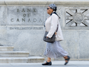 Une femme passe devant l’édifice de la Banque du Canada à Ottawa.  La Banque du Canada a maintenu son taux directeur à 5 % le 6 mars 2024.