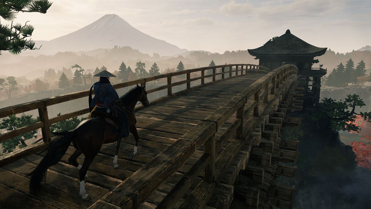 Un joueur chevauchant un cheval sur un pont en bois avec le mont Fuji visible au loin.