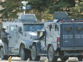 Les membres de l'équipe tactique de la police de Calgary et de la GRC surveillent une maison où des coups de feu ont été tirés jeudi.